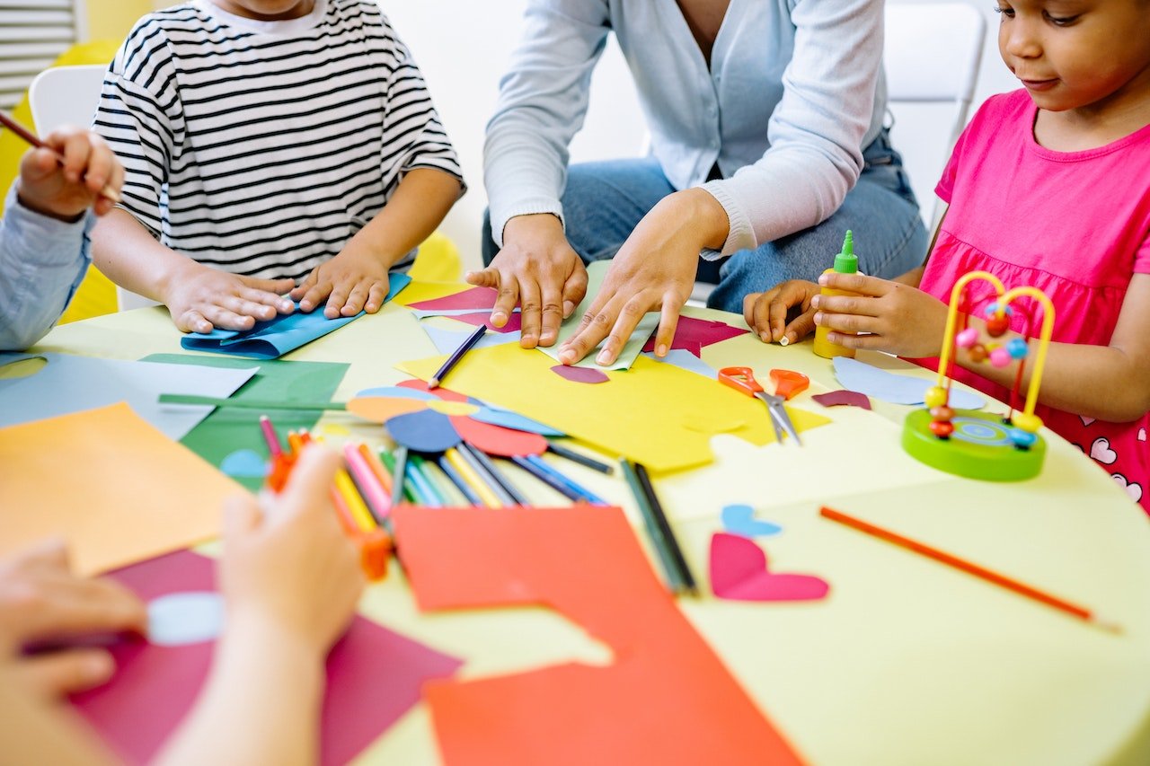 a teacher with her students doing arts and crafts