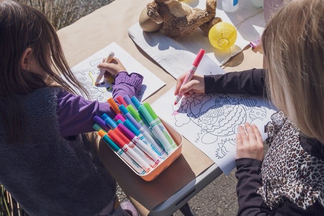 Young students coloring at a classroom table