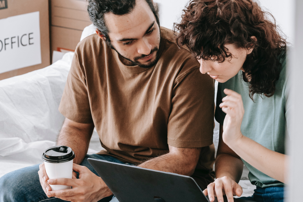 a couple looking for houses on a laptop